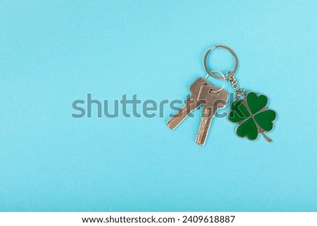Clover keychain with key ring  on a colored background. Concepts for real estate and moving home or renting property. Buying a property. Mock-up keychain.Copy space.