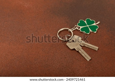 Clover keychain with key ring  on a colored background. Concepts for real estate and moving home or renting property. Buying a property. Mock-up keychain.Copy space.