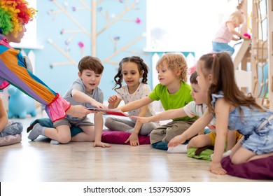 Clown amusing kids. Children are pulled to book - Shutterstock ID 1537953095