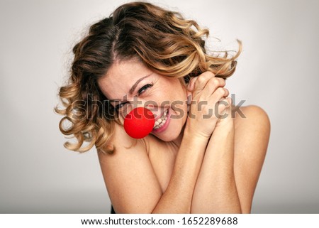 Clown girl with red nose with very funny gesture