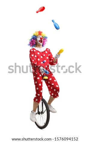 Clown on a unicycle juggling isolated on white background