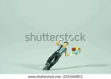 a clown rides on a unicycle, holds in one hand several colorful balloons, isolated on light background