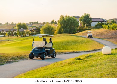 Club Car / Golf Cart In A Golf Resort With Green Lawns At Sunset. Luxury Vacation/ Holiday Concept.