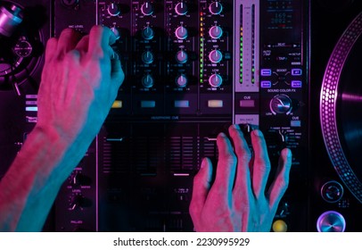 Club DJ mixing music with sound mixer device. Overhead photo of disc jockey playing set on party in the club. Disk jokey plays hip hop in nightclub - Shutterstock ID 2230995929