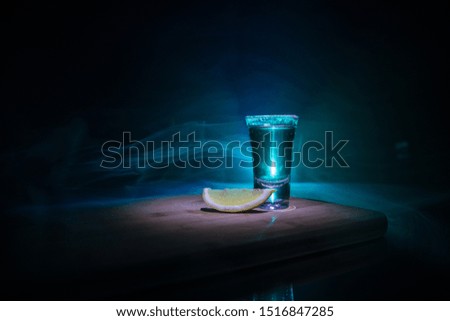 Club drink concept. Tasty alcohol drink cocktail tequila with lime and salt on vibrant dark background or glasses with tequila at a bar. Selective focus