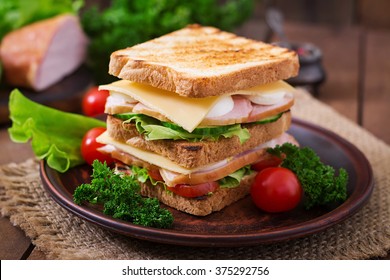 Club sandwich with cheese, cucumber, tomato, ham and eggs. - Powered by Shutterstock