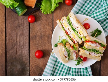 Club sandwich with cheese, cucumber, tomato, ham and eggs. Top view