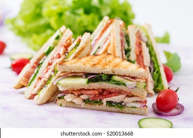 Club sandwich with chicken breast, bacon, tomato, cucumber and herbs - Powered by Shutterstock