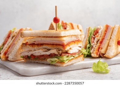 Club sandwich with ham, cheese, tomatoes, lettuce, and toasted bread