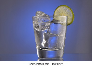 Club Soda On The Rocks With Lime Slice Garnish On Plain Background