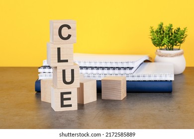 Clue Word Written On Wooden Cubes With Copy Space, Yellow Background