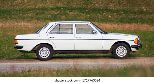 CLUJ-NAPOCA, August 5, 2011: Classic Mercedes-Benz W 123 white sedan car outdoor in nature at sunset