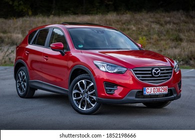 Cluj-Napoca, Cluj/Romania-01.11.2020-Mazda CX-5 in red metallic colour, AWD, isolated in an empty parking lot, autumn decor, 2016 manufacturing year