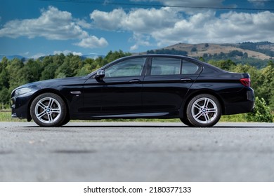 Cluj-Napoca, Cluj-Romania-06.06.2022-BMW F10, M Package, Isolated In An Empty Parking Lot, Carbon Black Metallic Paint, M Alloy Wheels And Xenon Headlights With Angel Eyes.