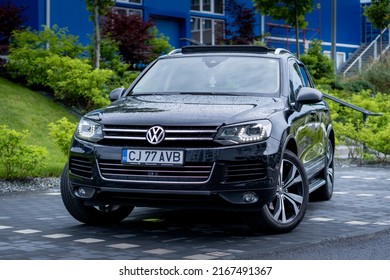 Cluj-Napoca, Cluj-Romania-06.13.2022-Beautiful Exclusive VW Touareg Black Metallic Paint With 20-inch Rims, Panoramic Sunroof, And Daylight Headlights Isolated In An Empty Parking Lot