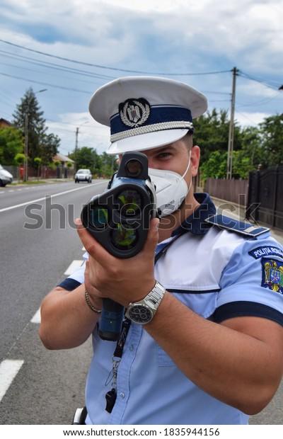 Cluj-Napoca,\
Cluj/Romania-Traffic police officers act in the street, wearing\
protective masks against COVID 19, using the radar gun to detect\
drivers exceeding legal\
speed