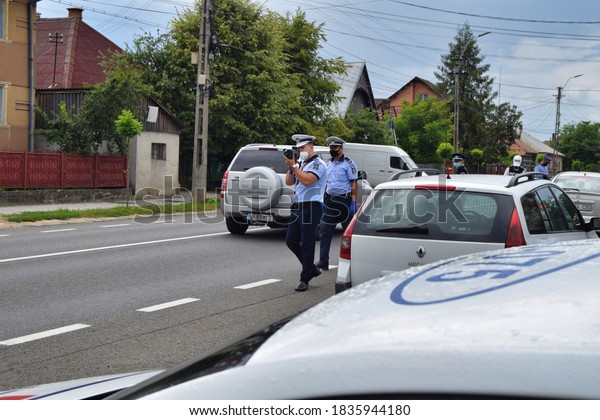 Cluj-Napoca,
Cluj/Romania-Traffic police officers act in the street, wearing
protective masks against COVID 19, using the radar gun to detect
drivers exceeding legal
speed