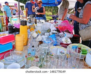 Cluj-Napoca, Romania - August 18, 2019: Vintage tableware for sale at the flea market. Secondhand porcelain plates, bowls, cups, glassware and used kitchen utensils on tables and in boxes.