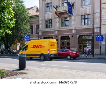 Cluj-Napoca, Romania - July 16, 2019: Yellow DHL van in traffic downtown. DHL Express is an international courier offering worldwide services, being a division of the German logistics company.