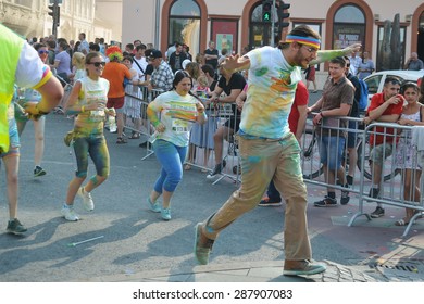 CLUJ-NAPOCA, ROMANIA - JUNE 13, 2015: Happy Runner With Glasses And Sweat Band On His Head Raises His Hands Close To The Finish Line At The Color Run.