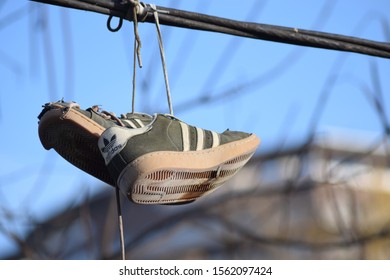 CLUJ-NAPOCA, ROMANIA - November 9, 2019:  Shoes And Pairs Of Sneaker Tied Together And Hanging From A Rope. Shoes On A Wire. Untangling An Urban Myth.