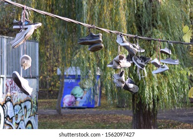 CLUJ-NAPOCA, ROMANIA - November 9, 2019:  Shoes And Pairs Of Sneaker Tied Together And Hanging From A Rope. Shoes On A Wire. Untangling An Urban Myth.