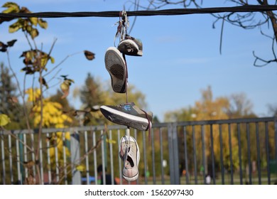 CLUJ-NAPOCA, ROMANIA - November 9, 2019:  Shoes And Pairs Of Sneaker Tied Together And Hanging From A Rope. Shoes On A Wire. Untangling An Urban Myth.