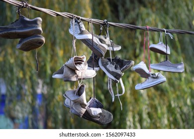 CLUJ-NAPOCA, ROMANIA - November 9, 2019:  Shoes And Pairs Of Sneaker Tied Together And Hanging From A Rope. Shoes On A Wire. Untangling An Urban Myth.