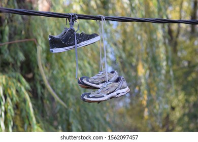 CLUJ-NAPOCA, ROMANIA - November 9, 2019:  Shoes And Pairs Of Sneaker Tied Together And Hanging From A Rope. Shoes On A Wire. Untangling An Urban Myth.