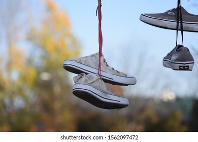 CLUJ-NAPOCA, ROMANIA - November 9, 2019:  Shoes And Pairs Of Sneaker Tied Together And Hanging From A Rope. Shoes On A Wire. Untangling An Urban Myth.