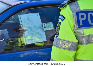 Cluj-Napoca,Cluj/Romania-04.12.2020-Police Agent, Romanian Traffic Police (Politia Rutiera) Driving License And Car Papers Check. During COVID 19 Pandemic,  All Papers Are Presented On The Car Window