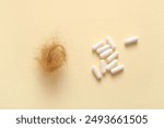 Clump of hair and pills on beige background. Hair loss problem