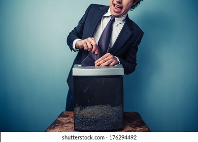 Clumsy Businessman With His Tie Stuck In A Paper Shredder