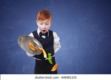 Clumsy Little Waiter Drops Food From Tray Serving Hamburger. Cheeseburger Falling With Separated Toppings. Dropping Burger Layers. Redhead Child Boy In Suit, Failure At Blue Background