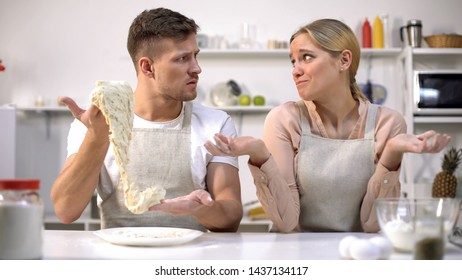 Clumsy Man Stretching Dough, Looking At Wife, Difficulties During Cooking