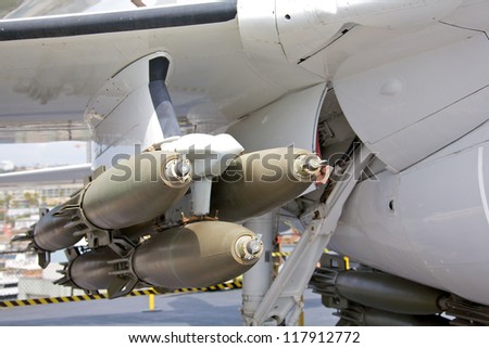 A cluster of bombs mounted under the wing of a modern fighter aircraft