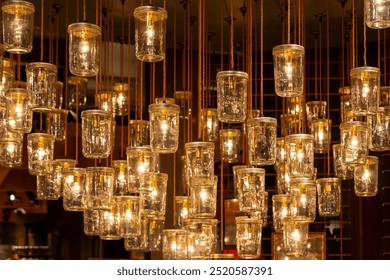 a cluster of mason jars hanging from the ceiling with lights inside