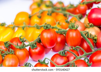 Cluster Of Red And Yellow Cherry Tomatoes On The White Background