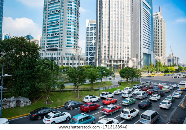 A cluster of tall buildings and cars on the\
highway in Shanghai