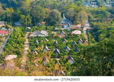 Cluster of triangular a-frame bungalows nestled in a lush orchard at Ban Tha Ton, Northern Thailand