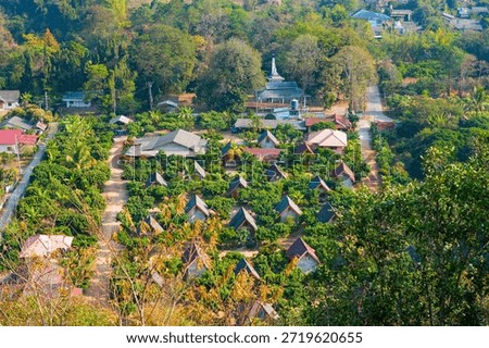 Cluster of triangular a-frame bungalows nestled in a lush orchard at Ban Tha Ton, Northern Thailand