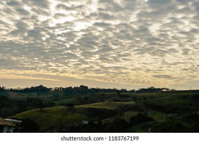 Clusters of black clouds Moving in the evening, and golden light from the sunset.