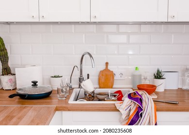 Clutter, Dirty Dishes By The Sink In The White Kitchen.