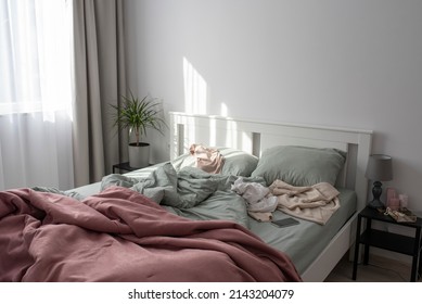 Cluttered bedroom with a pink and mint bedding 