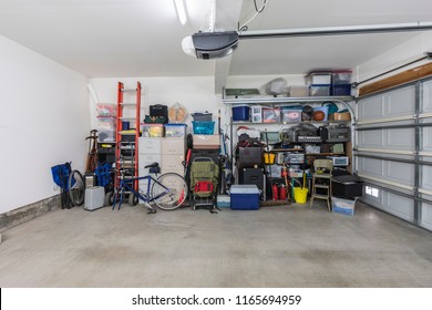 Cluttered but organized clean suburban residential two car garage with tools, file cabinets and sports equipment.  
