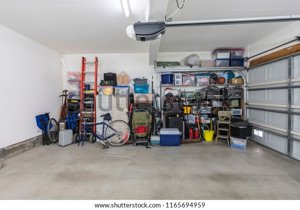 Cluttered but\
organized clean suburban residential two car garage with tools,\
file cabinets and sports equipment. \
