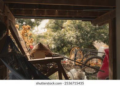 A cluttered outdoor space with various objects and greenery in the background, capturing a sense of rustic charm and disarray.