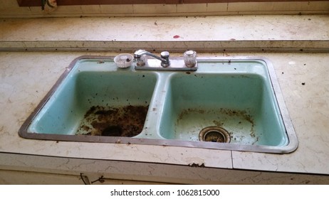 Clyde, NY/USA - 10/16/16: A filthy double sink in a kitchen that has not been cleaned by tenants in a long time. 