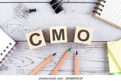 CMO Text On Wooden Block With Office Tools On Wooden Background