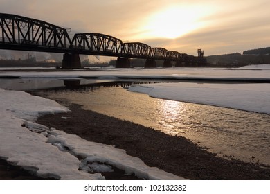 The CN Rail bridge at dawn. Built by the Grand Trunk Pacific Railway in 1914 over the Fraser River in Prince George, British Columbia, Canada. A pulp mill is operating in the background.